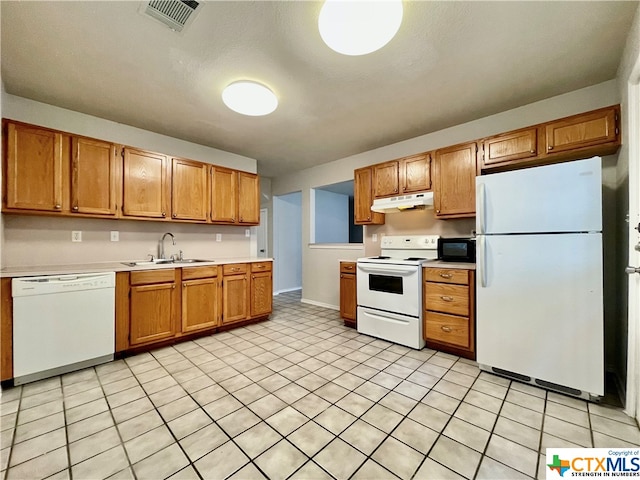 kitchen with white appliances, a textured ceiling, and sink