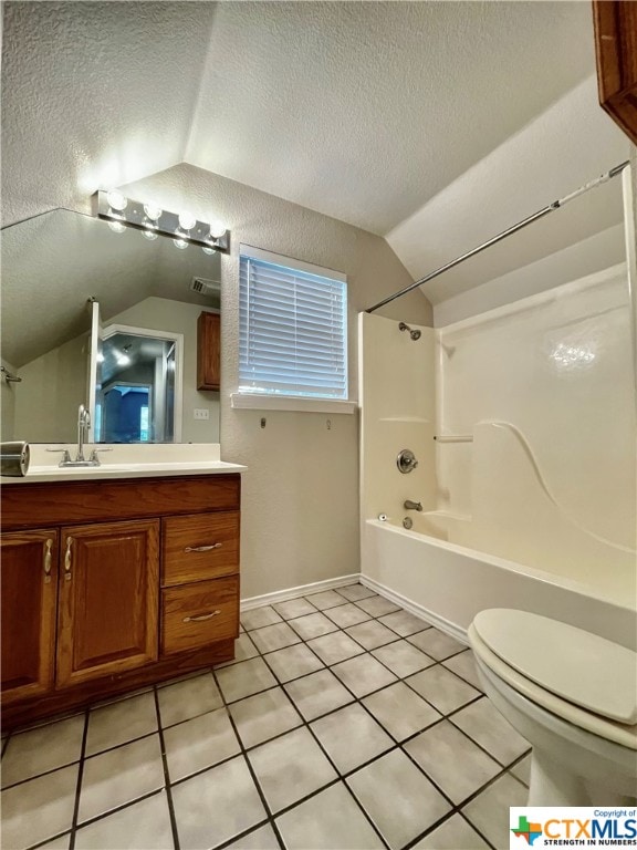 full bathroom with vaulted ceiling, tile patterned floors, and a textured ceiling