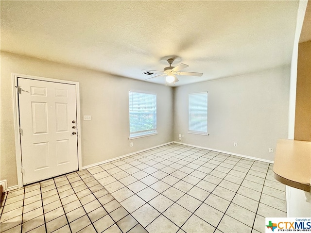 tiled foyer with ceiling fan and a textured ceiling