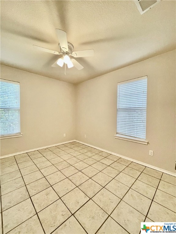 tiled spare room with ceiling fan and a textured ceiling