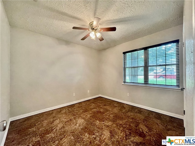 unfurnished room with ceiling fan and a textured ceiling