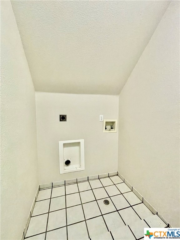 laundry room featuring washer hookup, a textured ceiling, light tile patterned flooring, and hookup for an electric dryer