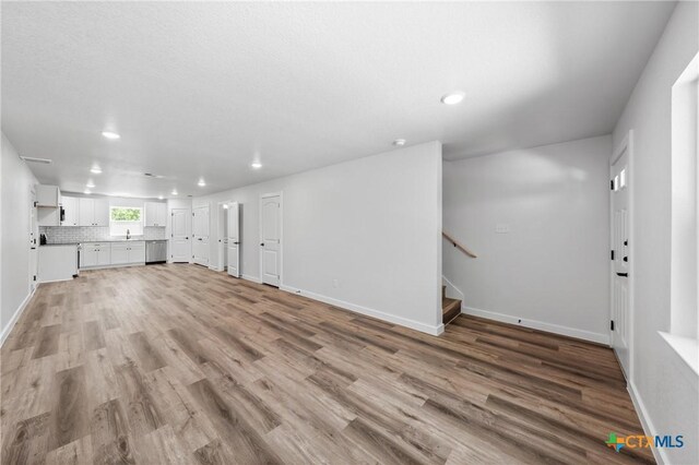 616 S 24th St, Temple, TX 76501 - unfurnished living room featuring recessed lighting, light wood finished floors, baseboards, and stairs