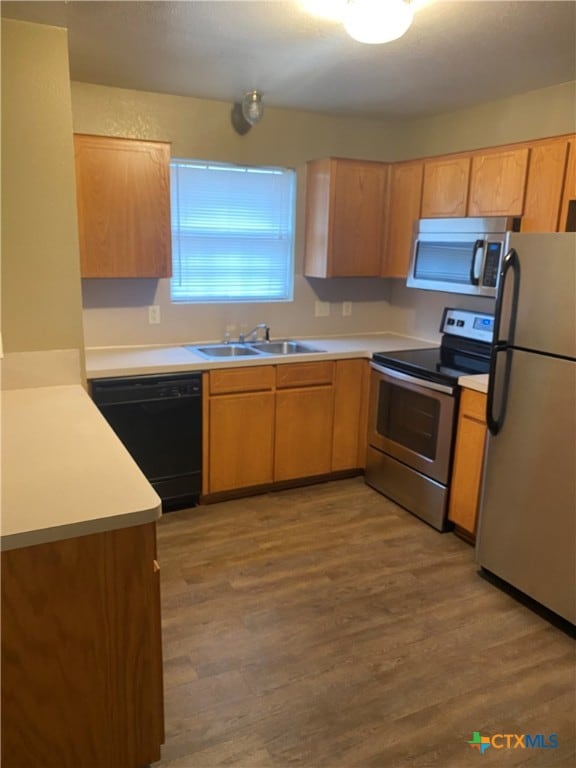 kitchen featuring appliances with stainless steel finishes, sink, and light hardwood / wood-style flooring