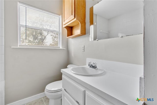 bathroom with toilet, vanity, and tile patterned floors