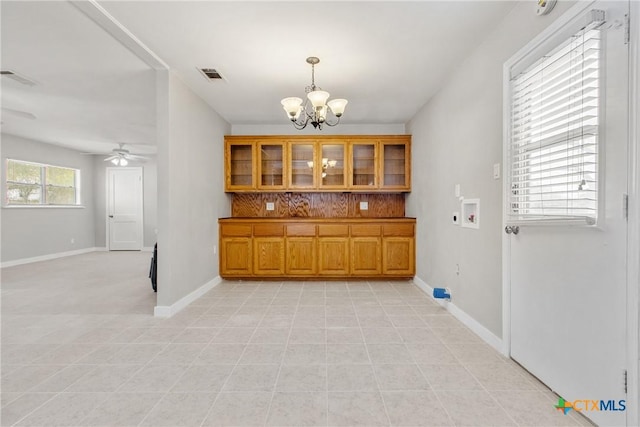 interior space with ceiling fan with notable chandelier and light tile patterned flooring