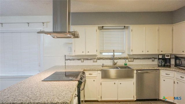 kitchen with island exhaust hood, backsplash, stainless steel appliances, sink, and white cabinetry