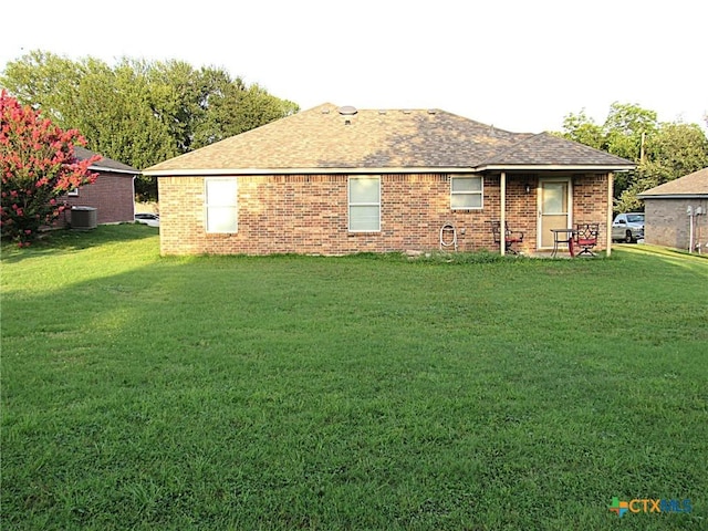 1104 N Blair St, Belton, TX 76513 - back of house featuring a yard, brick siding, and a shingled roof