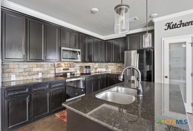 1606 Fiddle Wood Way, Temple, TX 76502 - kitchen featuring stainless steel appliances, crown molding, dark stone countertops, dark wood-type flooring, and decorative light fixtures