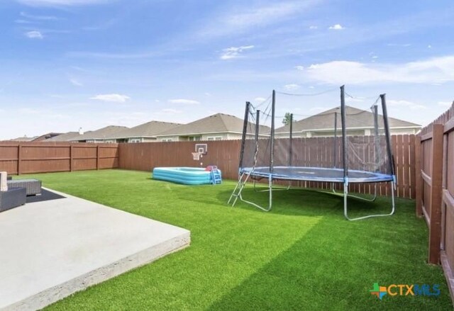 1606 Fiddle Wood Way, Temple, TX 76502 - fenced backyard featuring a trampoline and a patio
