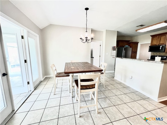 unfurnished dining area with a chandelier, light tile patterned floors, and vaulted ceiling