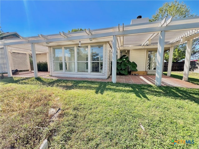 rear view of house featuring a patio, a pergola, and a yard