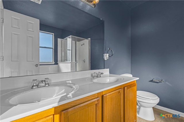 bathroom featuring walk in shower, vanity, tile patterned floors, and toilet