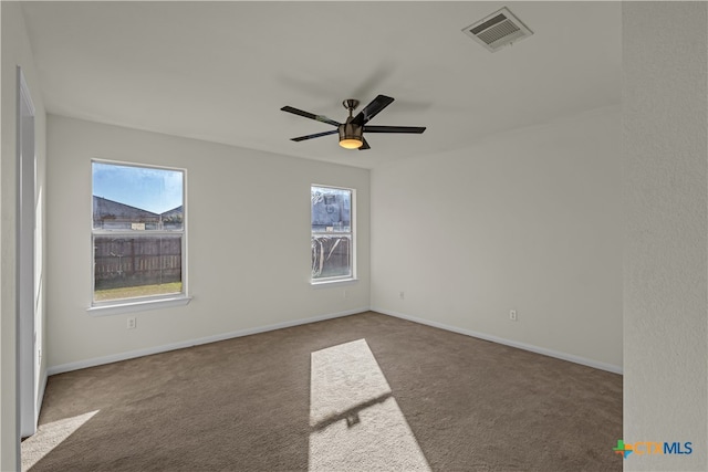 carpeted empty room with a wealth of natural light and ceiling fan