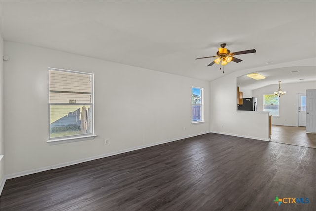 unfurnished living room featuring dark wood-type flooring, ceiling fan with notable chandelier, and vaulted ceiling