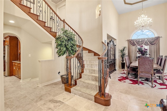 entryway with a high ceiling and a chandelier