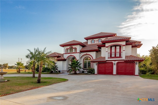 mediterranean / spanish-style home with a garage and a front yard