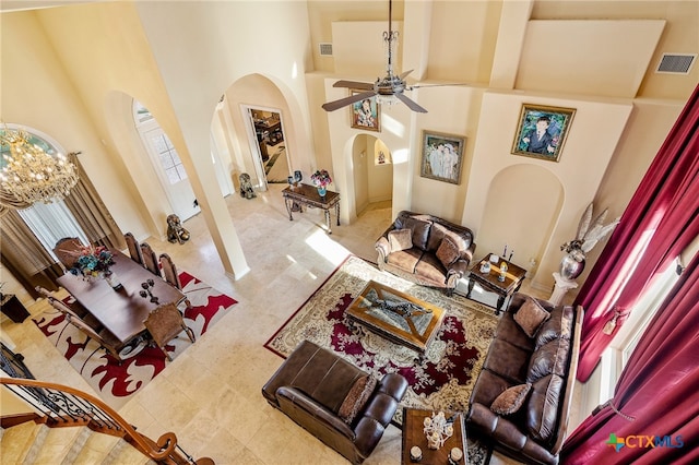 living room with a towering ceiling, beamed ceiling, and ceiling fan