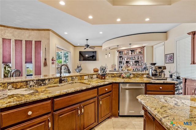 kitchen with light stone counters, light tile patterned floors, sink, dishwasher, and ceiling fan