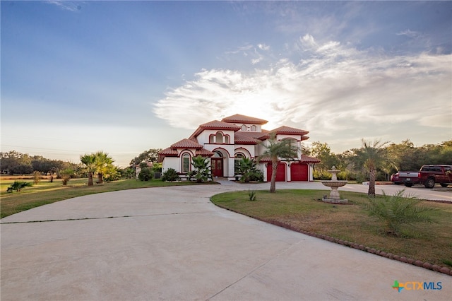 mediterranean / spanish-style home with a front lawn