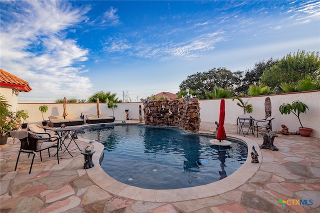 view of pool with a patio and pool water feature