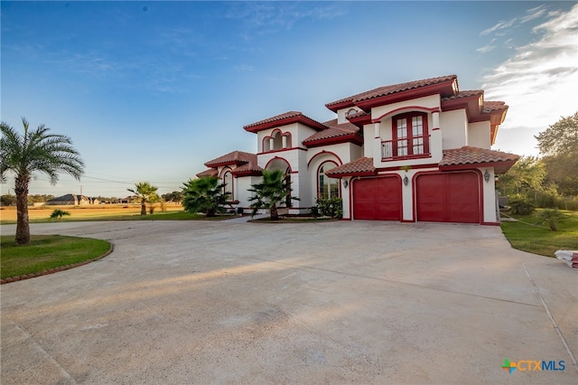 mediterranean / spanish home featuring a garage