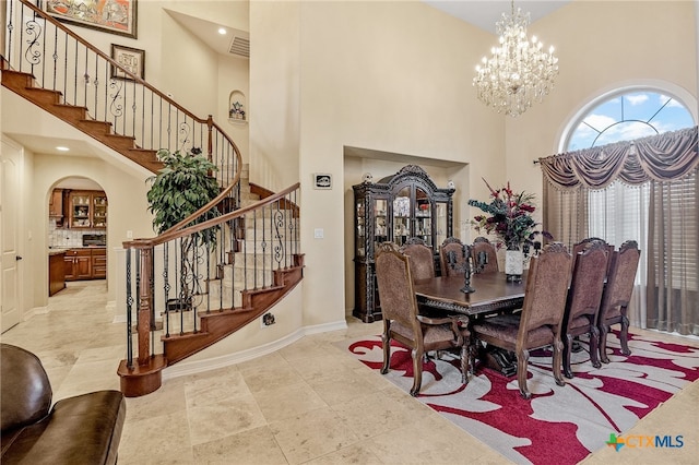 dining space featuring a high ceiling and an inviting chandelier