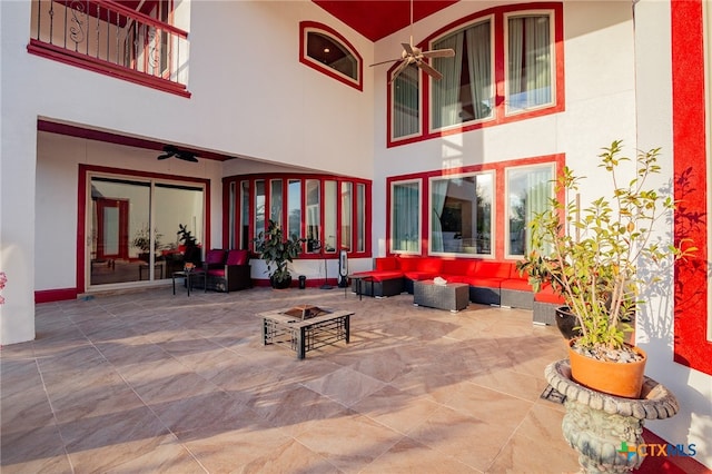 exterior space featuring a balcony, ceiling fan, and an outdoor living space