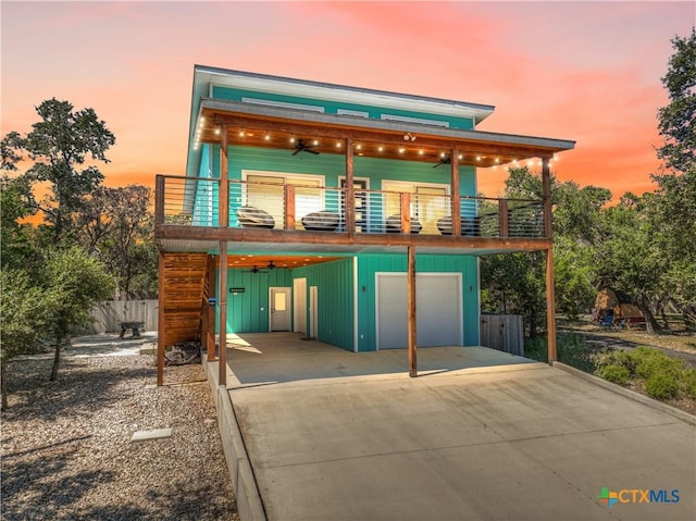 contemporary home with a garage, a balcony, and ceiling fan