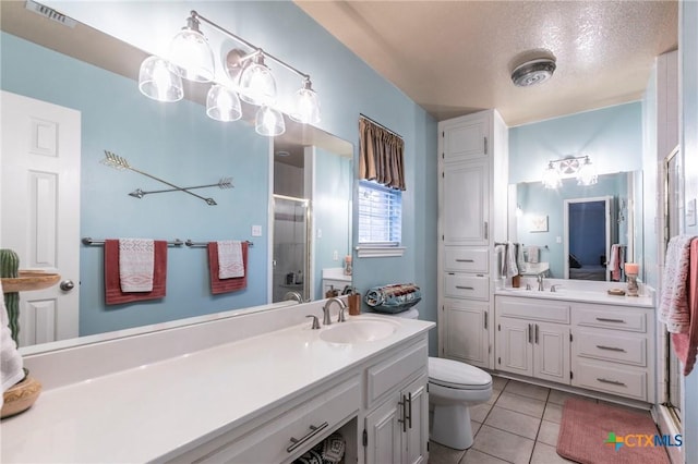 bathroom with vanity, walk in shower, toilet, tile patterned floors, and a textured ceiling