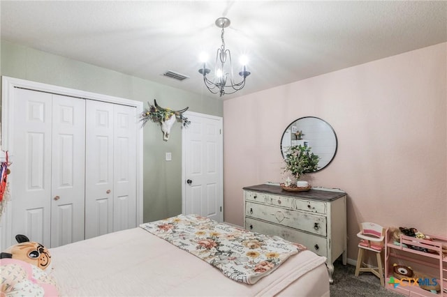 carpeted bedroom featuring a chandelier and a closet