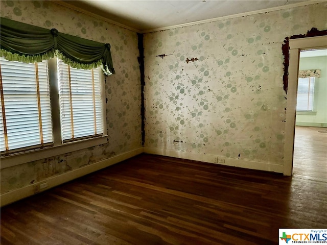 empty room featuring dark hardwood / wood-style floors and crown molding