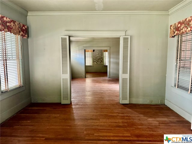 hallway featuring dark wood-type flooring, a wealth of natural light, and crown molding