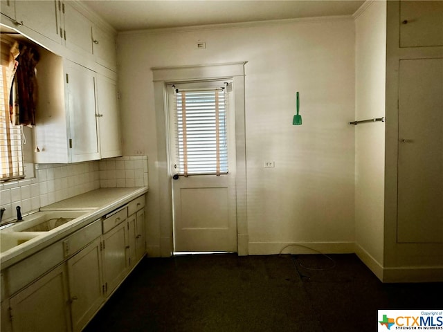 kitchen with ornamental molding, decorative backsplash, and white cabinetry