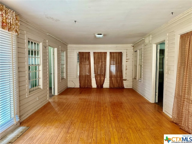 unfurnished room featuring wooden walls and light wood-type flooring