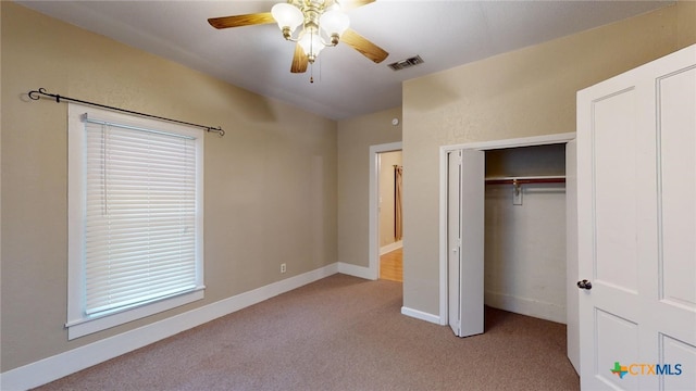 unfurnished bedroom with ceiling fan, light carpet, and a closet