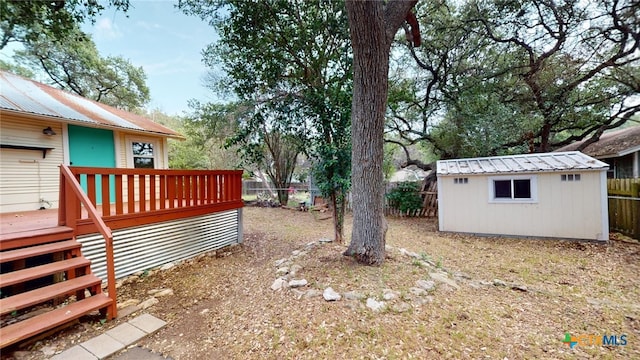 view of yard with a wooden deck and a storage shed