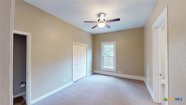 unfurnished bedroom with a closet, light colored carpet, and ceiling fan