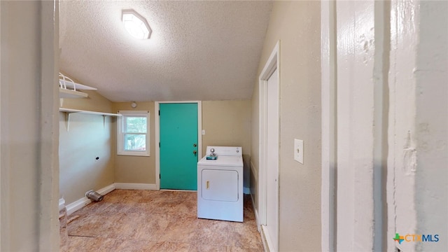 clothes washing area featuring a textured ceiling and washer / dryer