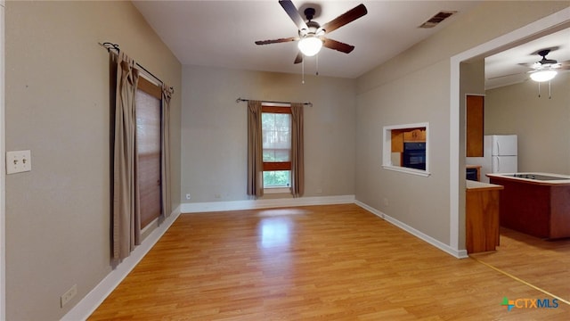 unfurnished room featuring light wood-type flooring and ceiling fan