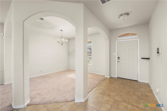 entrance foyer featuring a chandelier and light colored carpet