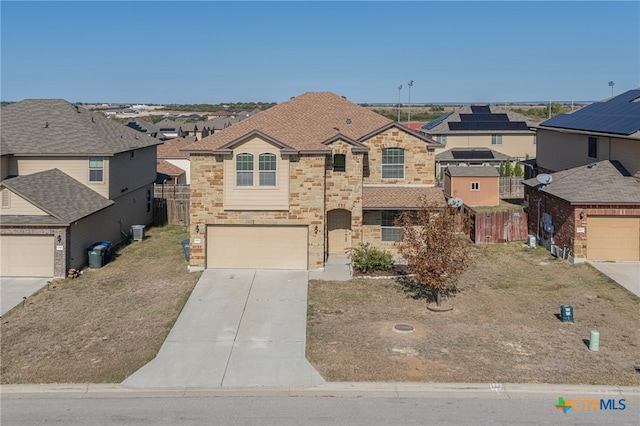 view of front of property with a garage and central AC