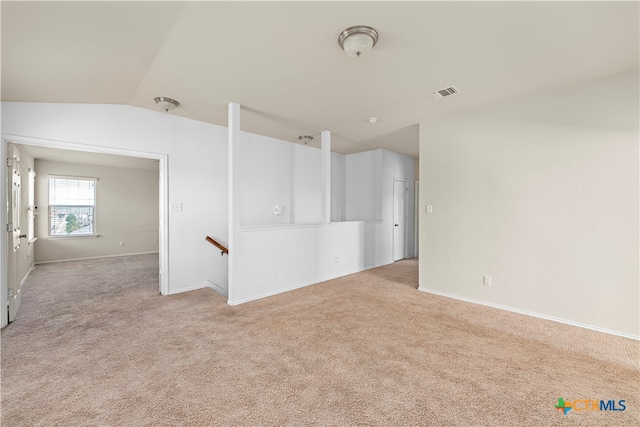 carpeted spare room featuring lofted ceiling