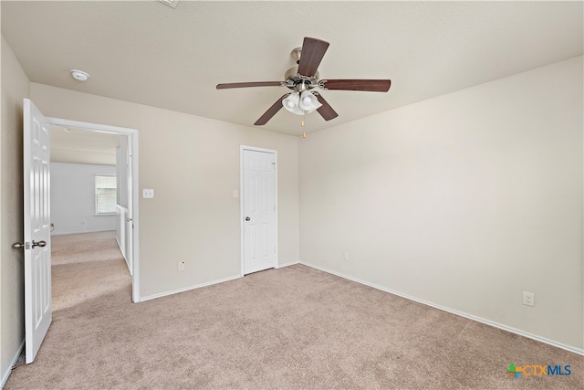 unfurnished bedroom with light colored carpet and ceiling fan