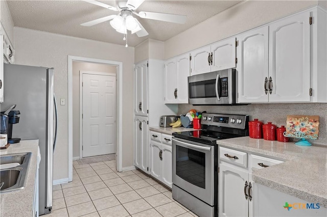 kitchen featuring white cabinets, stainless steel appliances, a ceiling fan, and light countertops