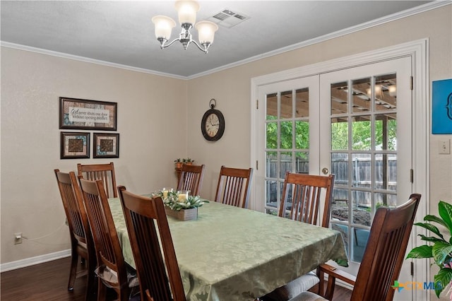 dining space with an inviting chandelier, ornamental molding, visible vents, wood finished floors, and baseboards