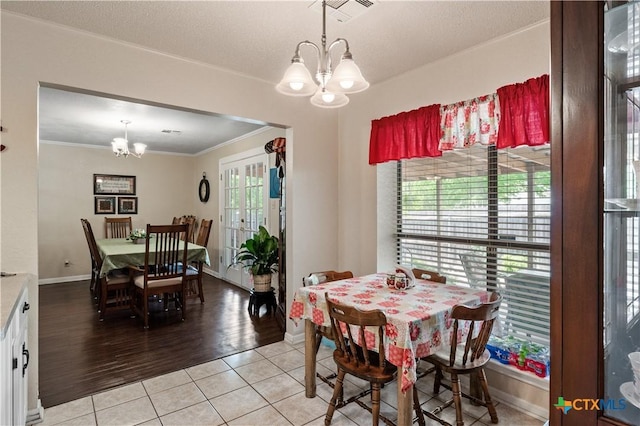 dining area featuring an inviting chandelier, ornamental molding, light tile patterned floors, and visible vents