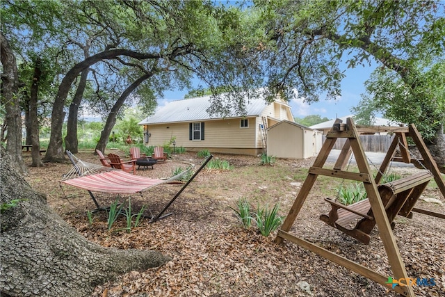 2265 Candlelight Dr, Canyon Lake, TX 78133 - back of property featuring a fire pit and a metal roof