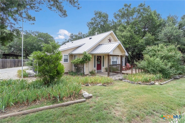 2265 Candlelight Dr, Canyon Lake, TX 78133 - view of front facade with a front yard, a metal roof, and covered porch