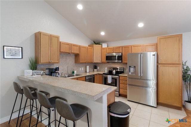 2265 Candlelight Dr, Canyon Lake, TX 78133 - kitchen with stainless steel appliances, a peninsula, tasteful backsplash, a breakfast bar, and lofted ceiling